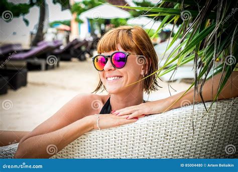 Het Ontspannen Op De Ligstoel Mooie Jonge Vrouwen Die In Zonnebril Op De Ligstoel Op Het Strand