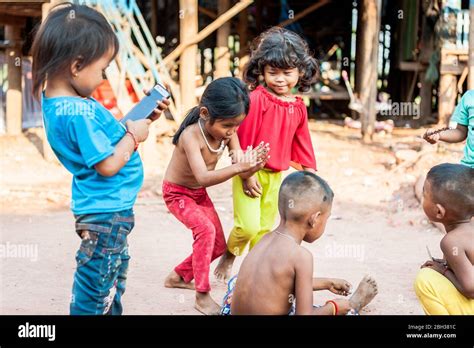 A Little Group Of Young Cambodian Children Play Along The Main Road At