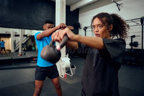 African American Male Personal Trainer Instructing African American