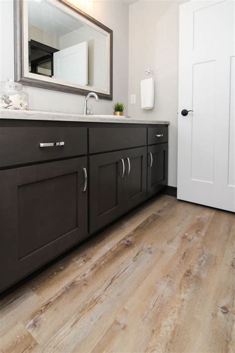A Bathroom With Wood Flooring And White Walls Is Pictured In This Image