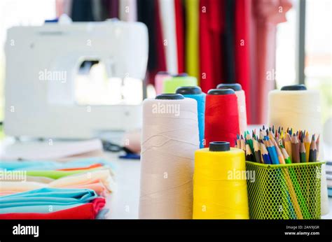 Front View Of Fashion Designer Working Desk With Colorful Sewing Thread Fabric And Colored