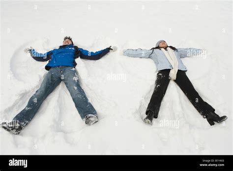 Young Couple Making Snow Angels Stock Photo Alamy