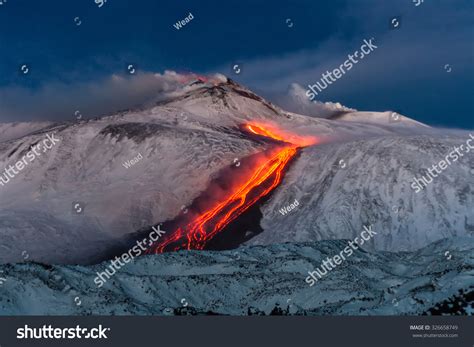 Mount etna is located on the east coast of sicily and prior eruptions have been elevated to at least seven kilometres above the summit, mainly due to prevailing winds. Volcano Etna Eruption - Lava Flow Through The Snow Stock ...
