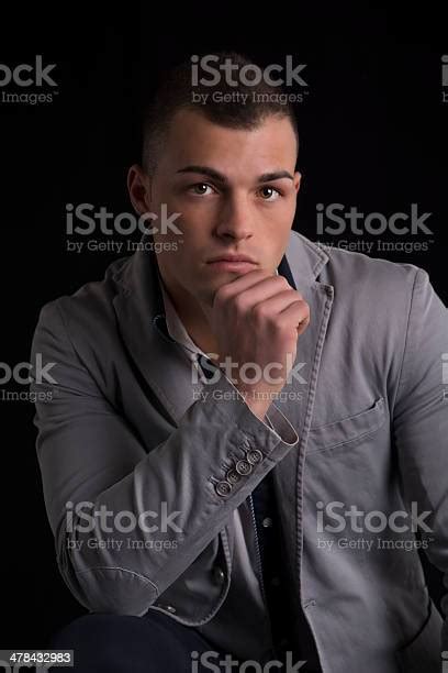 Portrait Of Handsome Young Man Resting Chin On His Hand Stock Photo
