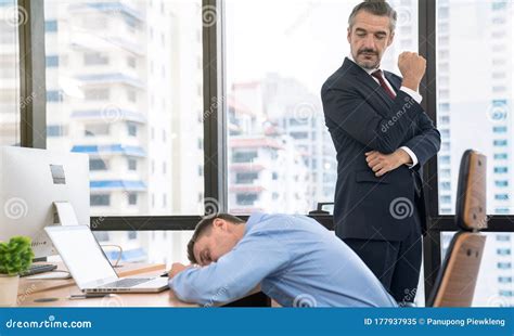 Boss Looks At His Lazy Staff While Sleeping During Work Hours Stock