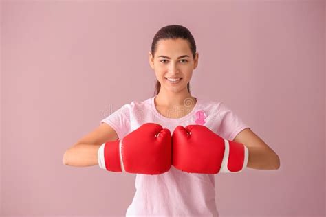 Beautiful Woman With Pink Ribbon And Boxing Gloves On Color Background