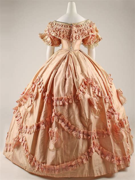 All are abundantly decorated with yards upon yards of lace, ruffles, and ribbon. 1860 - Cream silk evening dress | Fashion History Timeline
