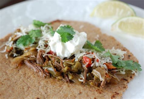 Flank steak is cooked in the crock pot with seasonings then served in tortillas with tomatoes and optional toppings. Recipe: Slow Cooker Flank Steak Fajitas - 100 Days of Real Food