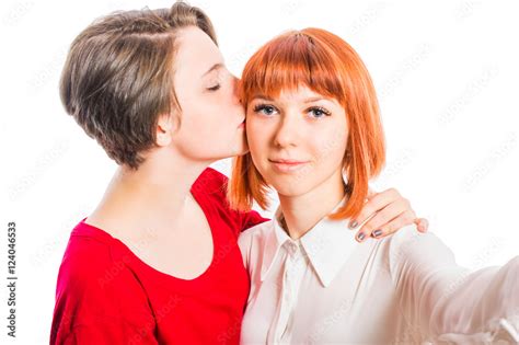 Two Lesbian Girls Hugging She Takes Selfie Kiss On The Cheek On White Isolated Background