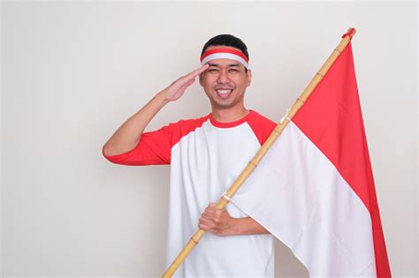 Pria Indonesia Memberi Hormat Saat Memegang Bendera Negara Dengan