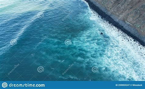 Aerial View Of Foamy Sea Waves Splashing Over The Shore Perfect For