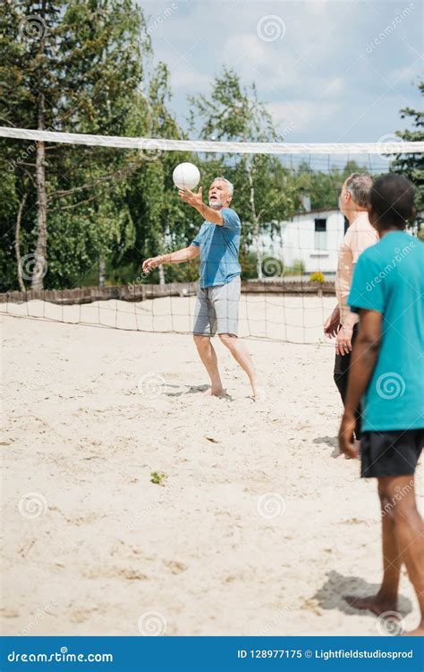 Selective Focus Of Multiethnic Old Men Playing Volleyball Together