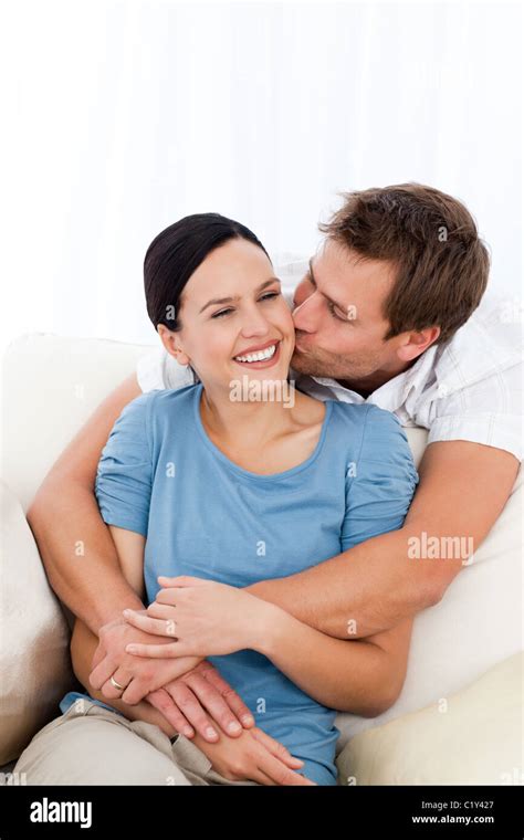 feliz el hombre besando a su novia mientras se relaja en el sofá fotografía de stock alamy