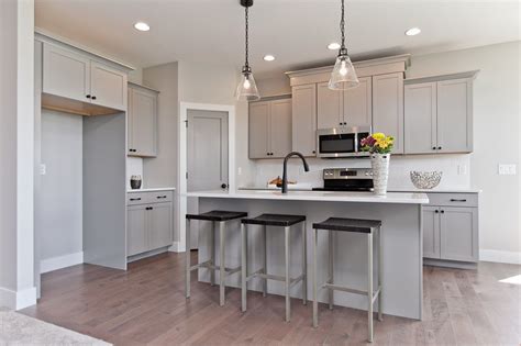 A look that's polished, clean and timeless. Stunning Marion, IA kitchen features grey cabinets, matte black fixtures and lighting and white ...