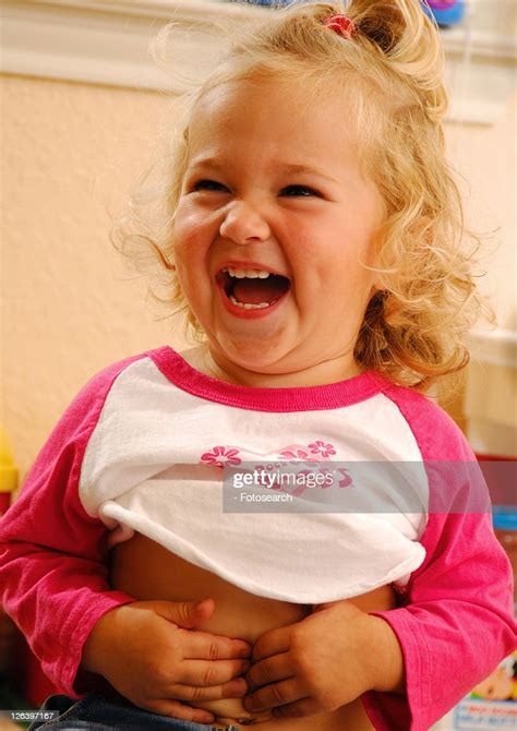 Closeup Of A Girl Touching Her Belly Button And Laughing High Res Stock