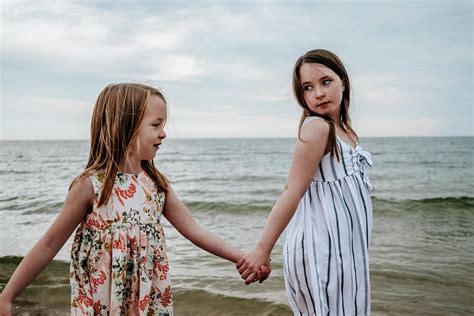 Portrait Of Sisters Holding Hands And Walking Near A Lake Photograph By Cavan Images Fine Art
