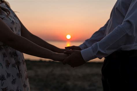 Couples In The Sunset Holding Hands