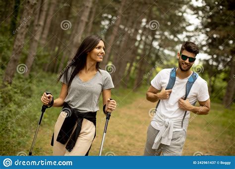 Couple Of Hikers With Backpacks Walk Through The Forest Stock Image