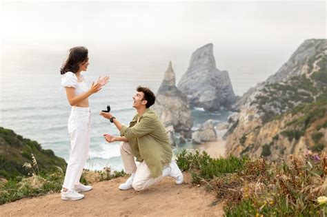 Premium Photo Happy Young Man Making Proposal To His Surprised Girlfriend Standing On Knee