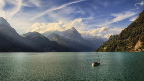 Lonesome Small Boat On The Lake Surrounded By The Mountains Wallpaper