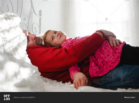 Dad And Daughter Cuddling On A Bed Stock Photo Offset