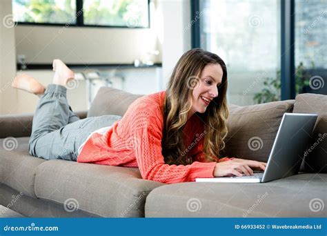 Smiling Woman Lying On The Couch On Her Laptop Stock Photo Image Of Brunette Relaxing