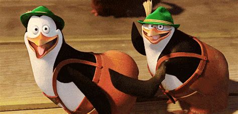 Two Animated Penguins Dressed In Green Hats And Carrying Luggage On