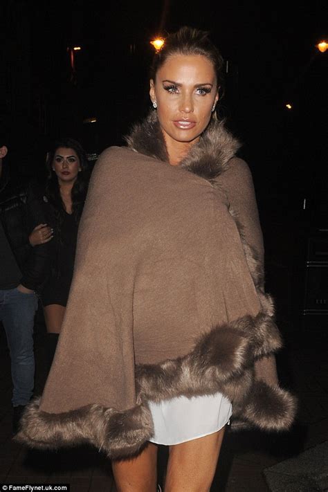 Katie Price Wears A Skimpy White Top With Boots And Furry Poncho