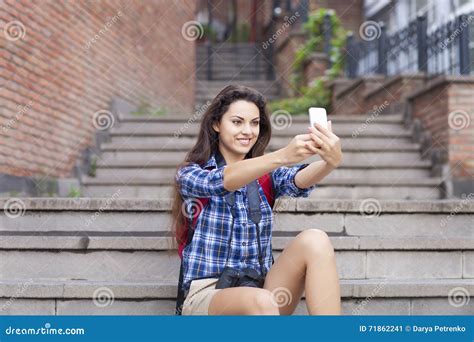 Portrait Of A Young Attractive Woman Holding A Smartphone Digital