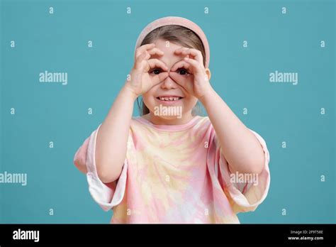 Portrait Of Funny Little Girl Making A Face At Camera Isolated On Blue