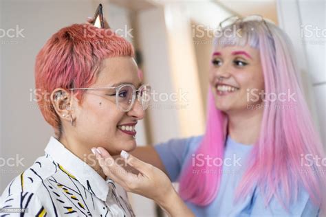 Lesbian Couple Taking Care Of Each Other Hair In The Bathroom Stock