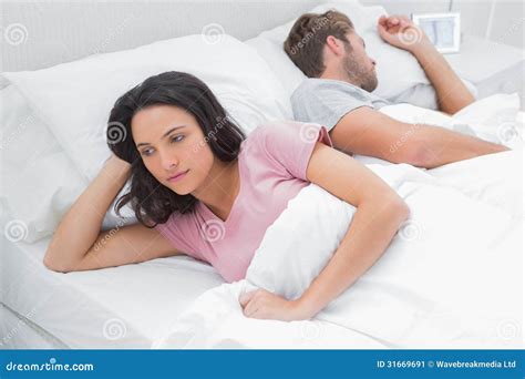 Woman Thinking In Her Bed Next To Her Sleeping Husband Stock Image