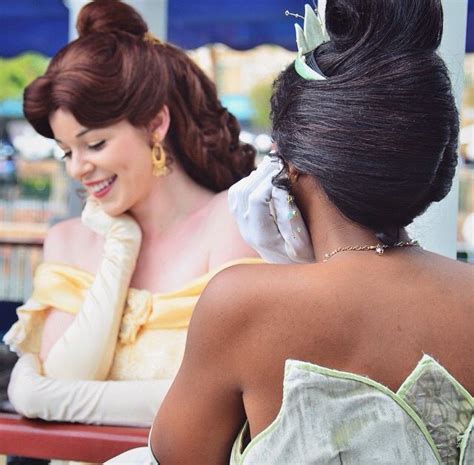 Two Women In Dresses Sitting At A Table