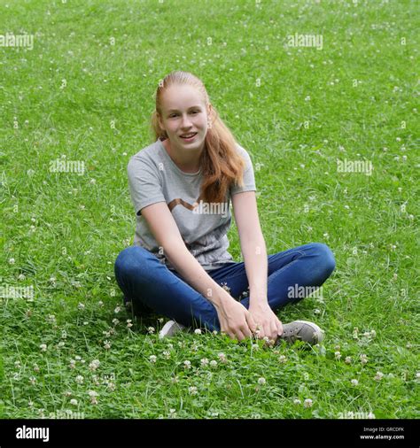 Teenager Young Girl Sitting Cross Legged On A Flower Meadow Stock
