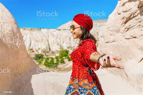 asian female traveler in the middle eastern desert in national dress with a turban follow me