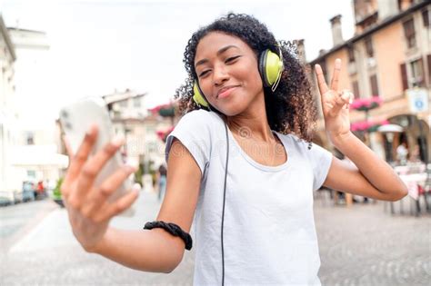 One Girl Using Smartphone And Listening To Music In The Street Stock