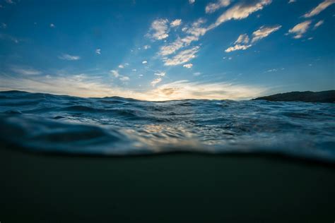Tranquilo Cuerpo De Agua De Mar Bajo Un Cielo Azul Claro · Fotos De