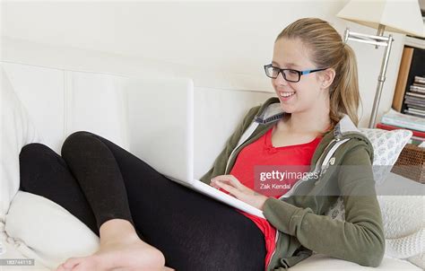 Teenage Girl Using Laptop On Sofa Smiling Photo Getty Images
