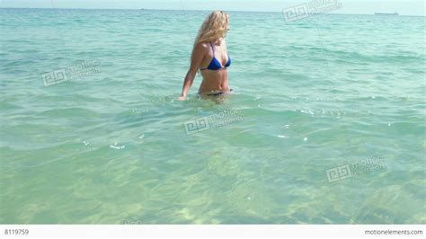 Smiling Blonde Woman Walking Into The Sea And Looking At Camera Stock Video Footage 8119759