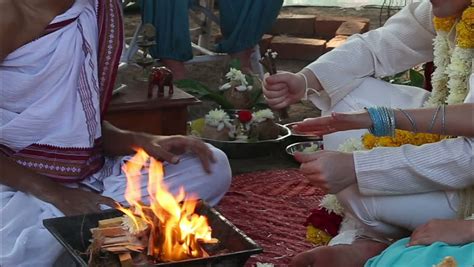 groom puts sticks in the sacred fire on the indian wedding ceremony stock footage video 7231933