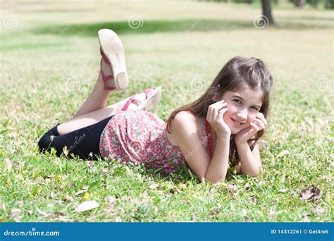 Happy Cute Girl Laying On A Grass Field Royalty Free Stock Photography