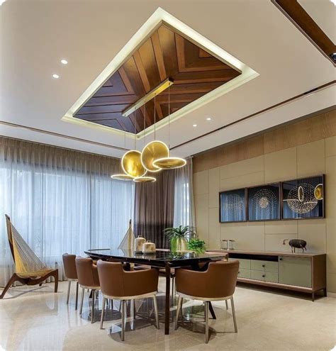 An Elegant Dining Room With Modern Lighting And Wood Paneled Ceiling