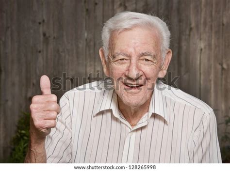 Стоковая фотография 128265998 Счастливый старик давая большие пальцы