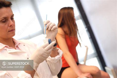Gynecologist Performing A Cervical Smear Or Pap Test On A Teenage