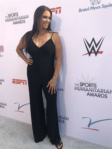 A Woman In Black Jumpsuits Posing For The Camera On A Red Carpet At An