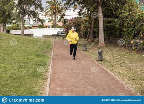 Curvy Woman Doing Jogging Routine Outdoor At City Park Focus On Face