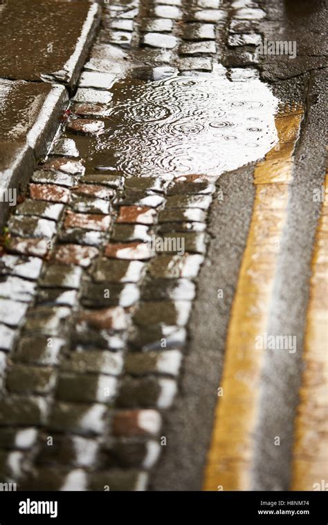 Rain And A Puddle On A Cobbled Street Stock Photo Alamy