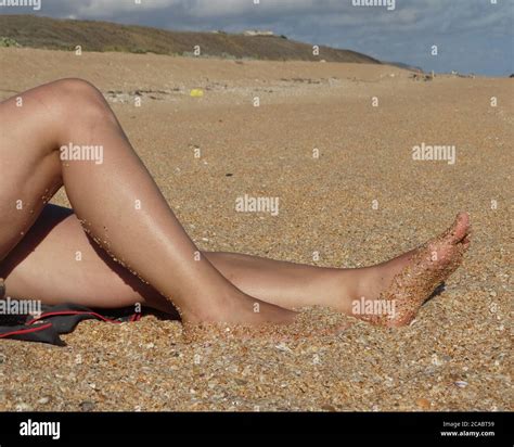 Women S Tanned Legs On The Sea Sand Stock Photo Alamy