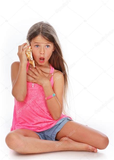 la niña está sorprendida por lo que oyó en la concha fotografía de stock © fxquadro 22206661