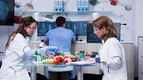 Female scientist testing GMO samples on vegetables in ...
